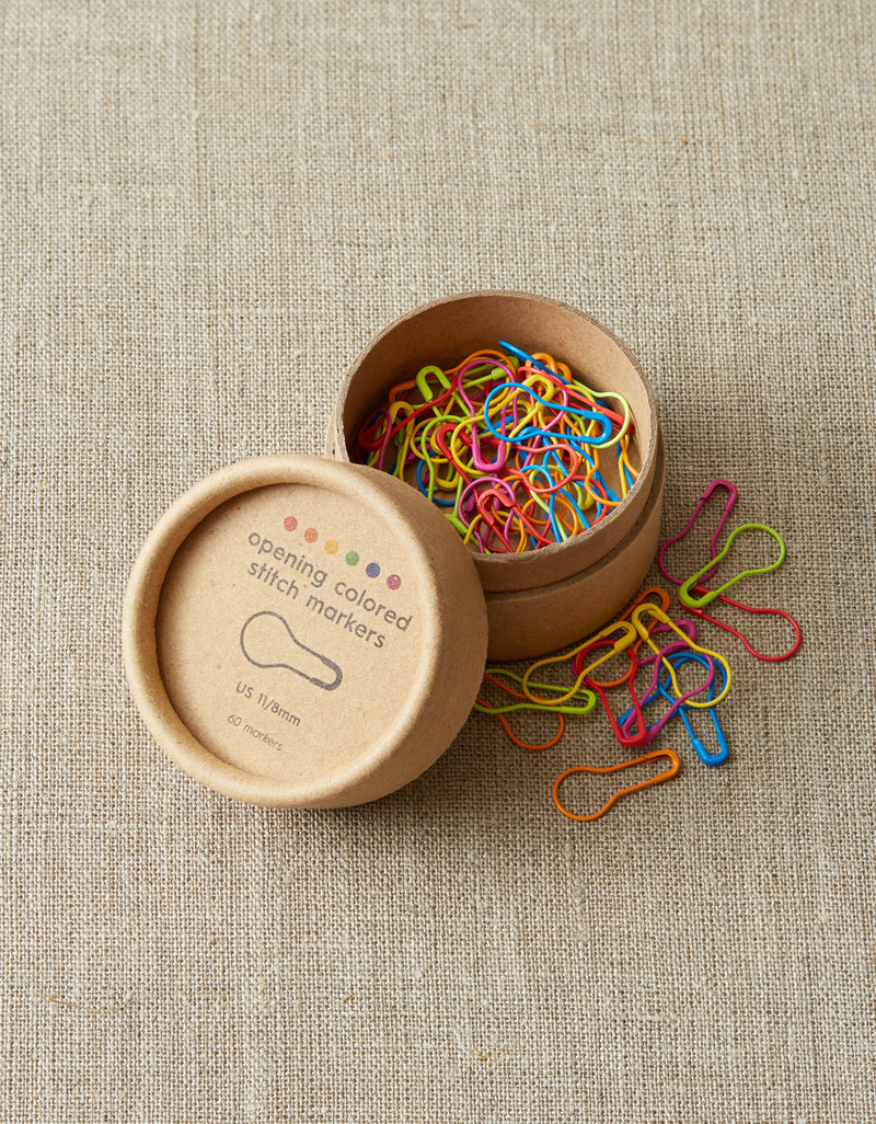  multicolored stitch marker set from cocoknits in a round kraft storage box